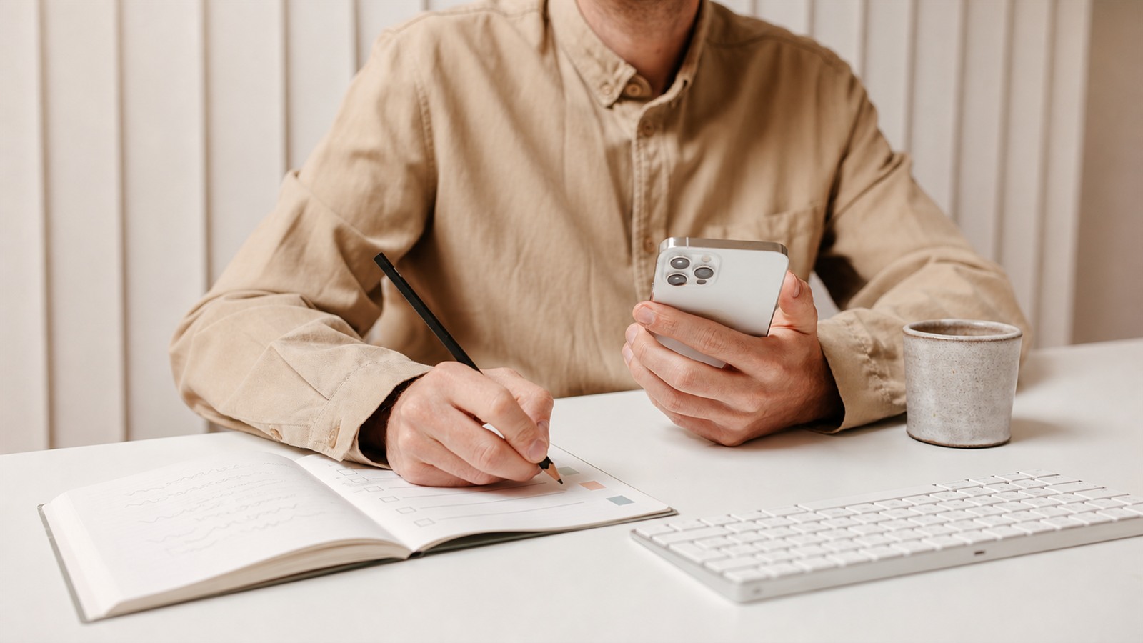 A person holding a smartphone while turning handwritten notes into an organized checklist